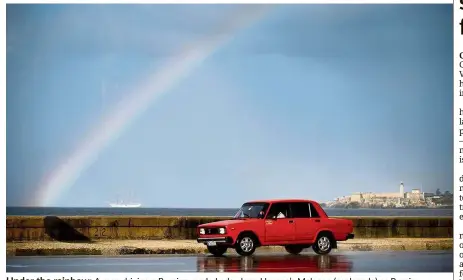  ??  ?? Under the rainbow: A man driving a Russian-made Lada along Havana’s Malecon (esplanade) as Russia advances its pawns in Cuba, rememberin­g the great era of the Soviet bloc. — AFP