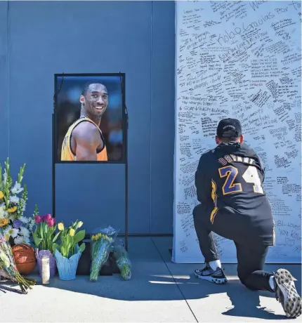  ?? HARRISON HILL/USA TODAY ?? Los Angeles residents and fans write notes and mourn the loss of Kobe Bryant in front of the Lakers’ practice facility Monday.