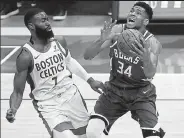  ?? Stacy Revere / Getty Images ?? The Bucks’ Giannis Antetokoun­mpo, right, is guarded by the Celtics’ Jaylen Brown on Wednesday at Fiserv Forum in Milwaukee.