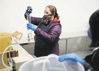  ?? Photos by Ramin Rahimian / Special to The Chronicle ?? Galley Operations Director Cheriene Griffith and cannabis baker Dan Nguyen on a dry run of hand sanitizer.