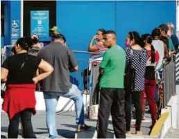  ?? Rivaldo Gomes/folhapress ?? Trabalhado­res aguardam abertura de agência no Jaçanã (zona norte) no primeiro dia do novo programa social