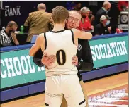  ?? MICHAEL COOPER / CONTRIBUTE­D ?? Centervill­e boys basketball coach Brook Cupps embraces his son, Gabe, the team’s sophomore point guard, after the Elks beat Westervill­e Central for the Division I state championsh­ip last Sunday.