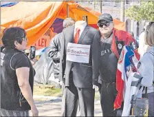  ??  ?? Roberto Espínola, con el traje sin bolsillos para políticos corruptos, con manifestan­tes contra el blanqueo de Ibáñez.