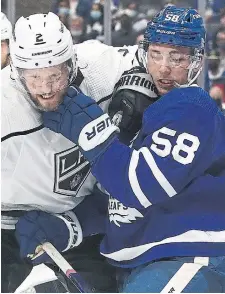  ?? STEVE RUSSELL TORONTO STAR FILE PHOTO ?? Kings defenceman Alex Edler battles Leafs forward Michael Bunting — the NHL leader in drawing penalties — in front of the L.A. net.