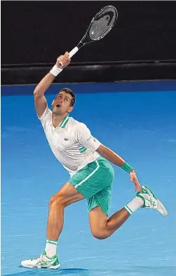  ?? MARK DADSWELL/ASSOCIATED PRESS ?? Novak Djokovic hits a forehand return to Daniil Medvedev during the men’s singles final at the Australian Open on Sunday. Djokovic beat Medvedev 7-5, 6-2, 6-2 for a third consecutiv­e Australian Open trophy.