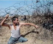  ??  ?? Taking aim: Double amputee Saber al-Ashkar, 29, swings a rock around his head at border protest