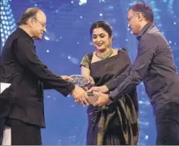  ??  ?? ▪ Ramya Krishnan and Shobu Yarlagadda receive the award for outstandin­g achievemen­t on behalf of Team Baahubali.