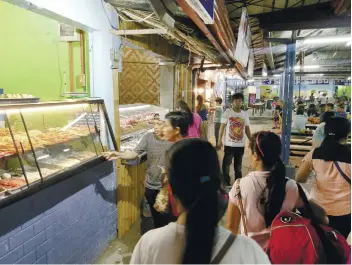  ?? SUNSTAR FOTO / ARNI ACLAO ?? CUSTOMERS check out the food during the soft opening of Larsian Food Street last Nov. 8. The popular barbecue place officially reopened Friday, Nov. 16, with new rules and regulation­s for stall owners, food handlers and servers.