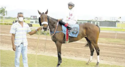  ?? (Photos: Garfield Robinson) ?? Trainer Leroy Tomlinson with his first of two winners, Portion to start the New Year’s Day card at Caymanas Park. The rider is Roger Hewitt.