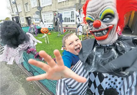  ??  ?? Louise Bertie’s son Alfie, 7, playing in his garden surrounded by spooky Halloween characters.