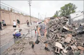  ?? Morry Gash The Associated Press ?? Volunteers clean up the Department of Correction­s building Tuesday in Kenosha, Wis. The building was burned during protests sparked by the shooting of Jacob Blake.