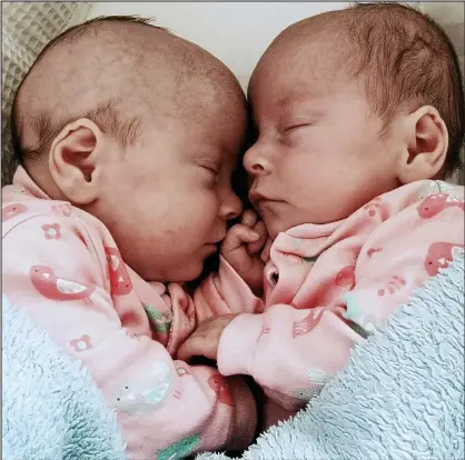  ??  ?? Close to you: In matching pink outfits, Eden, left, and Darcey curl up together after leaving hospital