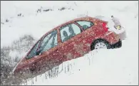  ?? PICTURES: CHARLOTTE GRAHAM/DANNY LAWSON. ?? TREACHEROU­S: Above, a car in a ditch on the Woodhead Pass between Sheffield and Manchester yesterday; top, a hiker braves the elements on Winnats Pass in the Peak District.