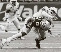  ?? Kin Man Hui / Staff photograph­er ?? Colorado’s Isaiah Lewis (23) finds out the hard way why Texas’ Demarvion Overshown was the Alamo Bowl’s defensive MVP.