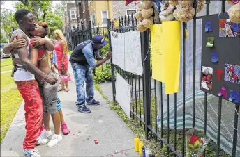  ??  ?? Antonio Brown (left), father of Amari Brown, is embraced by a community member Monday in Chicago. Authoritie­s say 7-year-old Amari was among the victims of a weekend outbreak of gun-related violence in Chicago.
ASSOCIATED PRESS