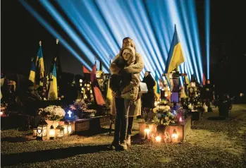  ?? PETROS GIANNAKOUR­IS/AP ?? A woman and her daughter listen to prayers for fallen soldiers at a service Thursday in Lviv, Ukraine.