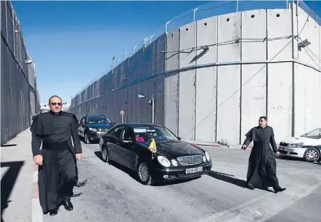  ?? Photos: REUTERS ?? Last Christmas: The Latin Patriarch of Jerusalem Fouad Twal, centre, is driven through an Israeli checkpoint as he enters the West Bank city of Bethlehem, to attend Christmas