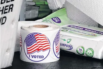  ?? BING GUAN • REUTERS ?? A roll of “I Voted” stickers is seen next to a packet of alcohol wipes at a drive-thru early voting site in the City Hall parking lot in Eau Claire, Wisc., on Friday.
