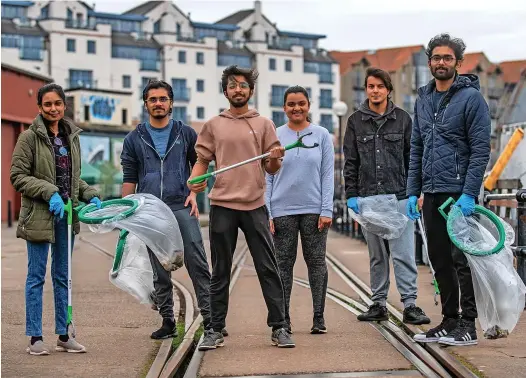  ?? PHOTOS: ADAM HUGHES/ SWNS ?? Vivek Gurav on the Harboursid­e with members of the ‘plogging’ group that he has set up