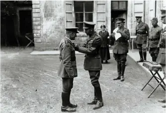  ?? (HMP) ?? ■ H.M. King George V presenting the Victoria Cross to the Reverend Theodore Bayley Hardy VC, DSO, MC at the Third Army’s headquarte­rs at Frohen-le-Grande, 9 August 1918. Padre Hardy’s daughter, Elizabeth Hardy, who was serving with the Red Cross at Dunkirk, can also be seen in the background. Chronologi­cally, Hardy’s VC was the 978th awarded. Following her father’s death, Elizabeth received a telegram of regret and sympathy from the King.