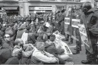  ?? AP PHOTO ?? Pro-independen­ce demonstrat­ors block a road, during a sitdown protest outside the Barcelona office of the state prosecutor, in Barcelona, Spain, Tuesday.