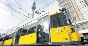  ?? MICHAEL SOHN THE ASSOCIATED PRESS ?? A tram drives in front of the Berlin TV Tower. Berlin’s complex public transport system composed of buses, subway trains, commuter railways and trams was divided between East and West until reunificat­ion.