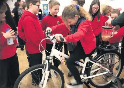  ??  ?? Pupils from Nantymoel Primary School use pedal power to make a fruit smoothie at a celebratio­n event at Nantymoel Boys and Girls Club Memorial Hall