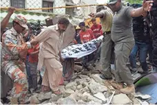  ?? RIZWAN TABASSUM, AFP/GETTY IMAGES ?? Pakistani crews move a body from a collapsed building in July. The United States has threatened Afghanista­n’s neighbor with sanctions for giving safe haven to terrorists.