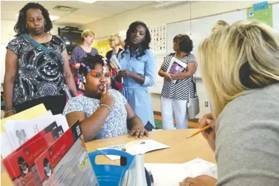  ?? STAFF PHOTOS BY ROBIN RUDD ?? Katie Hamby, literacy coach with Barger Academy/Bess T. Shepherd schools, works Tuesday with Hardy Hope participan­t Markayla McGhee as Hamilton County elementary principals observe.