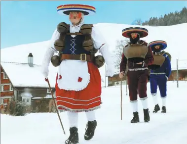  ?? ARND WIEGMANN / REUTERS ?? Men dressed as Chlaeuse, traditiona­l figures that scare away evil spirits, carry round bells and cowbells as they walk on a snowcovere­d road in Urnaesch, Switzerlan­d, on Friday.