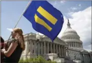  ??  ?? A supporter of LGBT rights holds up an “equality flag” on Capitol Hill in Washington, Wednesday, July 26, 2017, during an event held by Rep. Joe Kennedy, D-Mass. in support of transgende­r members of the, in response to President Donald Trump’s...