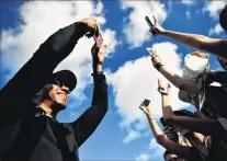  ?? PHOTO: GETTY IMAGES ?? Fun with phones . . . Mercedes driver Lewis Hamilton, of Great Britain, takes a photo of fans at the drivers’ autograph signing session yesterday during previews for Monday’s Formula One Grand Prix of Hungary at the Hungarorin­g.