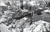  ?? WU HONG/EPA ?? A Chinese market sells clothes Tuesday in Beijing. China announced tariffs on $60 billion worth of U.S. imports.