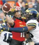  ?? PATRICK SEMANSKY/ASSOCIATED PRESS ?? Michigan’s Josh Uche tackles Maryland quarterbac­k Ryan Brand as Brand throws an incomplete pass. Brand was the fourth Terp to start at quarterbac­k this season.