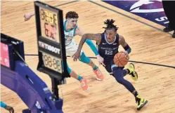  ?? BRANDON DILL/AP ?? Grizzlies guard Ja Morant (12) drives against Hornets guard LaMelo Ball in the first half Wednesday in Memphis, Tenn.