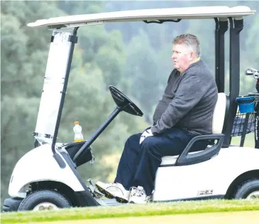  ??  ?? Anthony Cunningham seeks some shelter before hitting off at the Trafalgar Monthly Medal on Saturday afternoon..