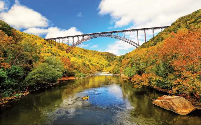  ??  ?? The massive steel New River Gorge Bridge (above) is a base for jumpers on Bridge Day in October (right).