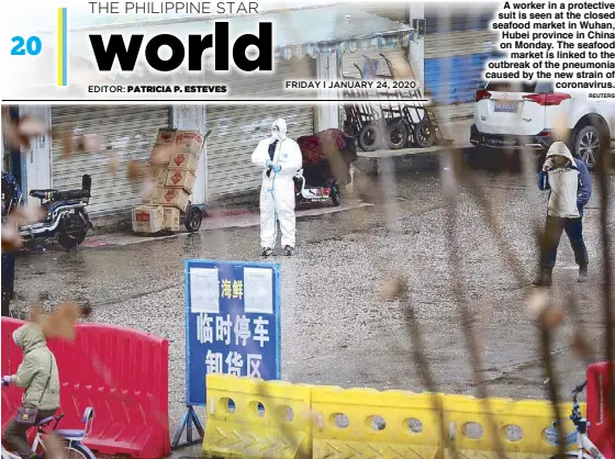  ?? REUTERS ?? A worker in a protective suit is seen at the closed seafood market in Wuhan, Hubei province in China on Monday. The seafood market is linked to the outbreak of the pneumonia caused by the new strain of coronaviru­s.