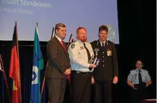  ??  ?? AWARDED: Senior Constable Greg Porter (centre) accepts his National Police Service Medal from (left) Police Minister Mark Ryan and Superinten­dent Mark Kelly.