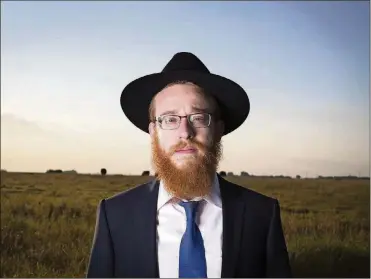  ?? RENEE JONES SCHNEIDER/ MINNEAPOLI­S STAR TRIBUNE ?? RabbiMende­l Alperowitz hasmoved his family fromBrookl­yn, N.Y., to Sioux Falls, S.D., to be the first rabbi to live in the state since the late 1970s. Hewas photograph­ed in a prairie on Aug. 23 in Sioux Falls, S.D.