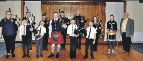  ?? Photograph: Katie Laing ?? Callum, centre, with tutors, young pipers and Dr John Smith, chairman of the Lewis and Harris Piping Society, far right.