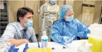  ?? REUTERS FILE ?? Prime Minister Justin Trudeau, seen here visiting a facility processing Pfizer vacccines, and his wife Sophie Gregoire Trudeau received Astrazenec­a shots at an Ottawa pharmacy on April 23.