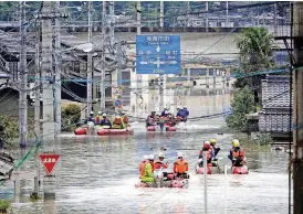  ?? [PHOTO BY KOJI HARADA, KYODO NEWS VIA AP] ?? Rescuers on boats Sunday search for stranded people after heavy rain in Kurashiki city, Okayama prefecture, southweste­rn Japan.