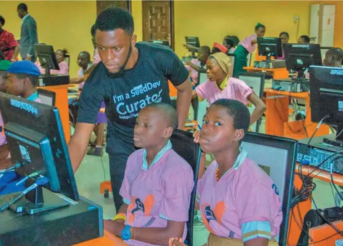  ??  ?? A SeedDev curator teaching school kids computer basics