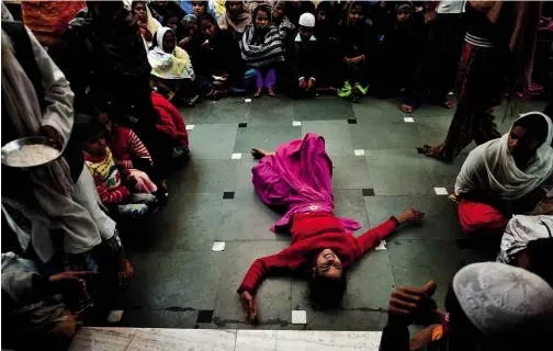  ??  ?? ABOVE: A young Indian woman believed to be possessed by evil spirits goes into a state of trance at the 650-year-old shrine of Sufi Saint Hazrat Shahdana Wali.