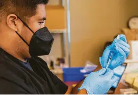  ?? Santiago Mejia / The Chronicle ?? Paul Marigmen prepares a Pfizer vaccine at the Mountain View Community Center. Pfizer has asked that its boosters be approved for those 16 and older.