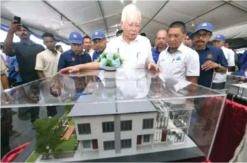  ??  ?? Najib looks at the a housing model for the 1Malaysia Civil Servants Housing Project (PPA1M) in Kampung Padang Tembak. — Bernama photo