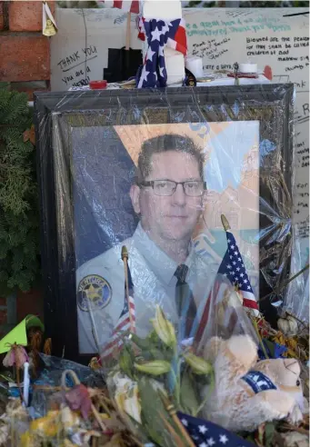  ?? AP ?? SAD NEWS: A photo at a memorial for Sgt. Ron Helus is seen yesterday in Thousand Oaks, Calif. Authoritie­s say Helus, killed in a mass shooting at a Southern California bar in November, was shot five times by the gunman, but was fatally struck by a bullet fired by a highway patrolman.