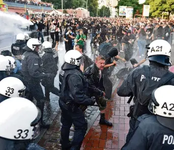  ?? AFP ?? Die Polizei geht bei der «Welcome to Hell»-Demo mit Wasserwerf­ern gegen Demonstran­ten vor.