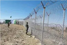  ?? AP ?? Pakistani soldiers stand guard near the fence at Angore Adda border, Pakistan. About 13 per cent of a fence planned along the 2,343km long disputed border has also been completed.